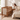 Mother sitting next to Boori Noosa Cot Bed in Pecan